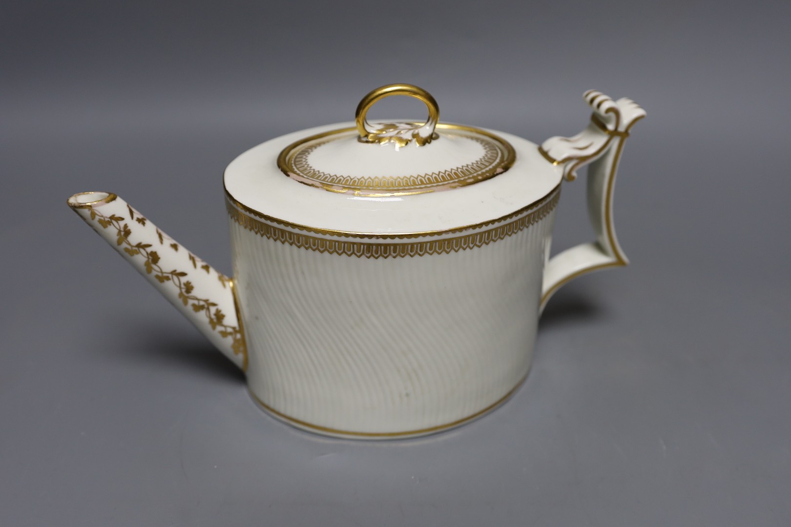 A Derby puce mark teapot and cover, late 18th century, with wavy parallel moulding with ornate gilded decoration, pattern to base. 26cm